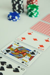 carte da poker messe in fila e sullo sfondo fisches del casinò
