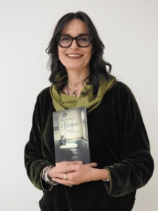 l'autrice alessandra limetti tiene in mano il suo libro A perdere. Un gico senza amore mostrando la copertina sulla violenza di genere nei casi di gioco d'azzardo patologico 